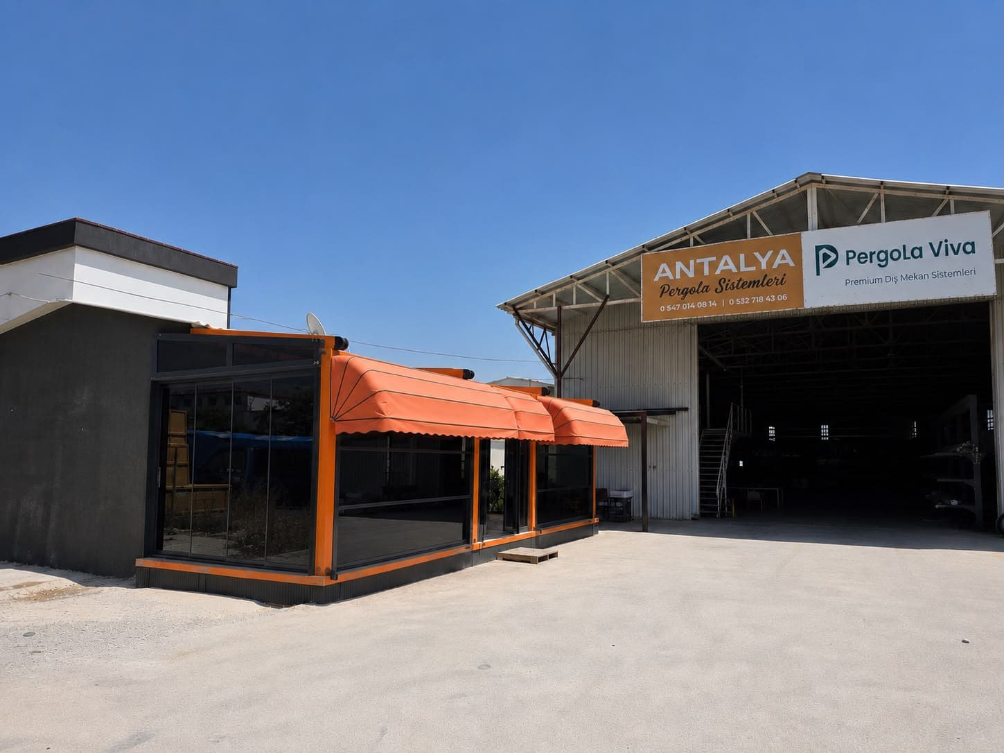 Pergola Viva üretim tesisinin giriş cephesi; tabelada firma adı ve iletişim numaraları, önünde tenteli ve camlı sergi ünitesi.