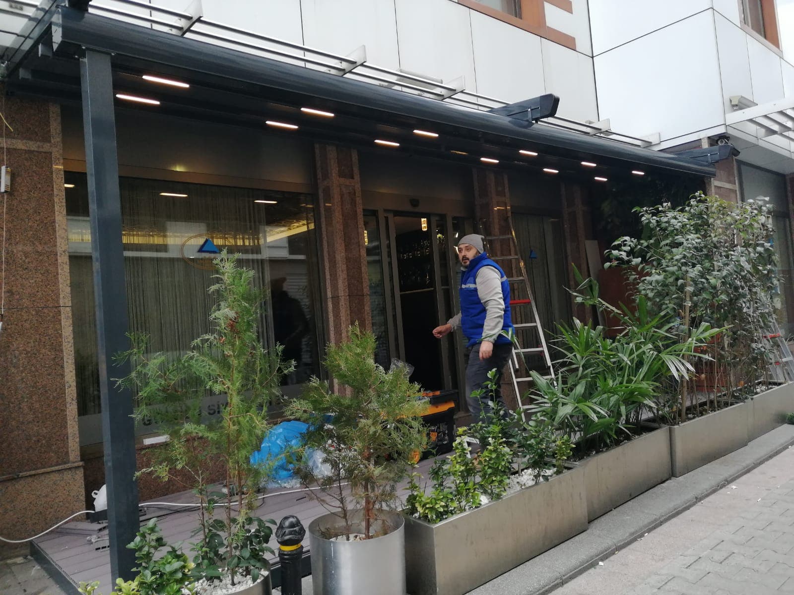 Ticari bir cephede devam eden montaj çalışması; alüminyum konstrüksiyon ve montaj ekibinden bir çalışan.